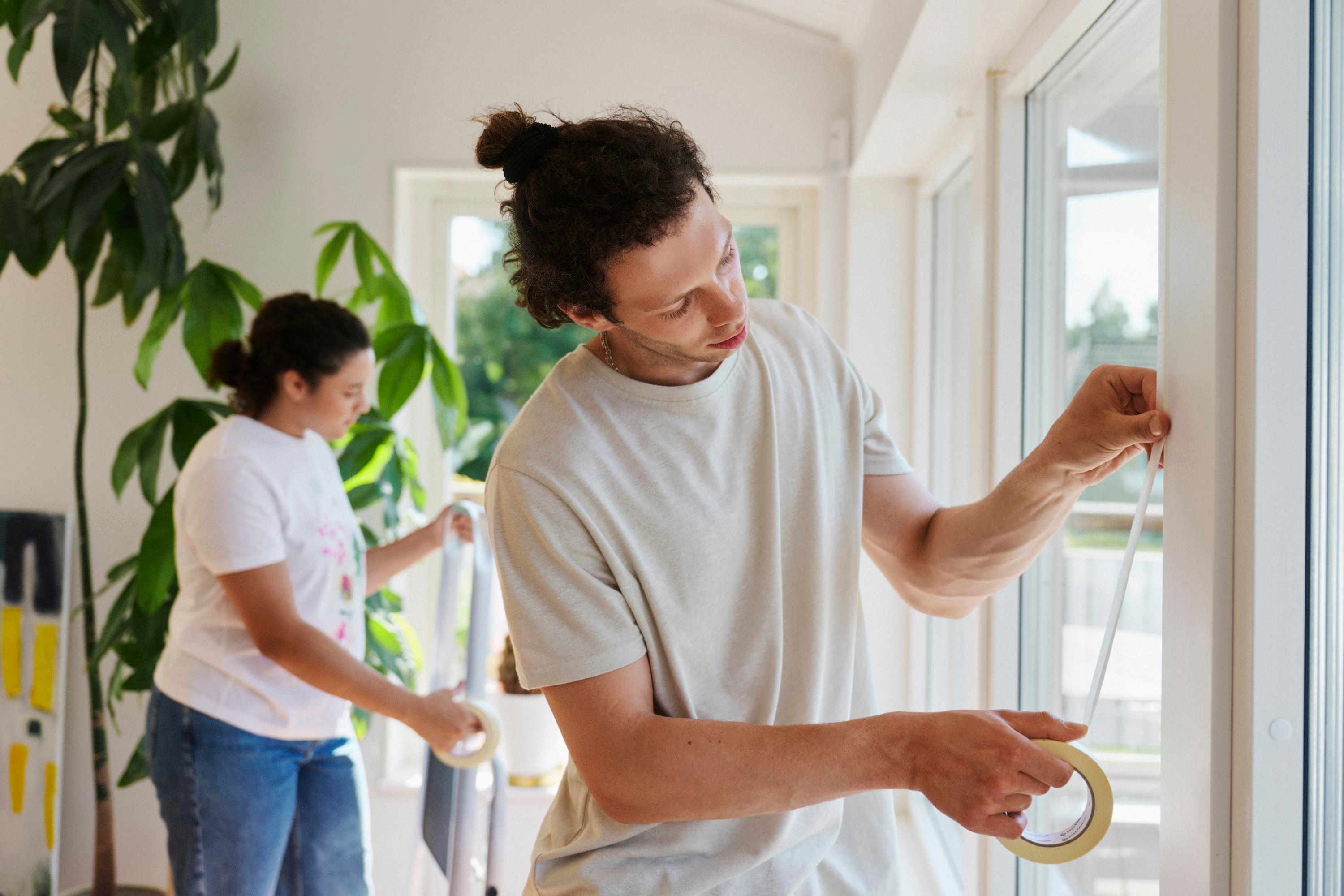 Två unga personer renoverar inne i ett hus