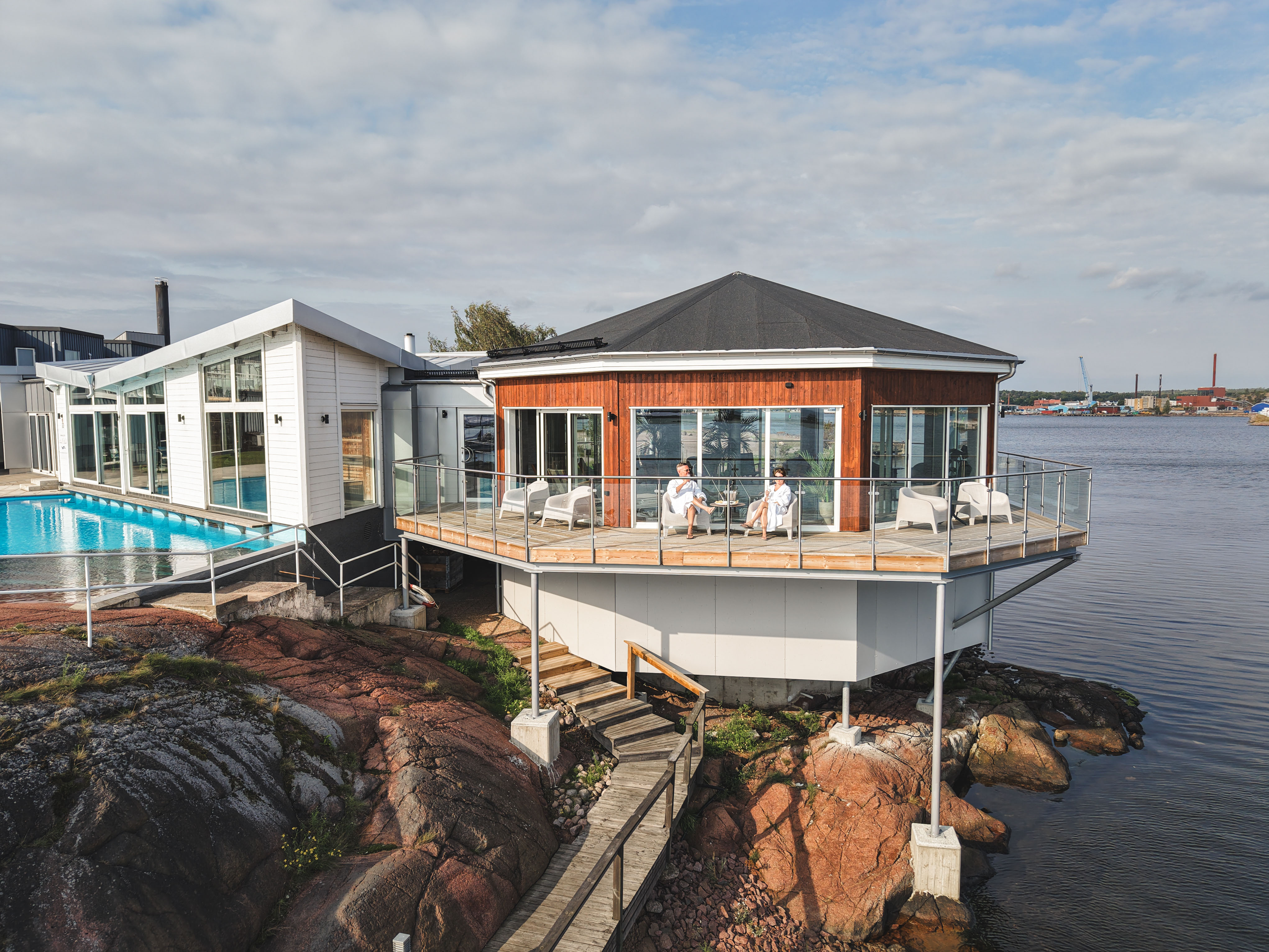 Modern spa-terrass vid vattnet på klippig strand