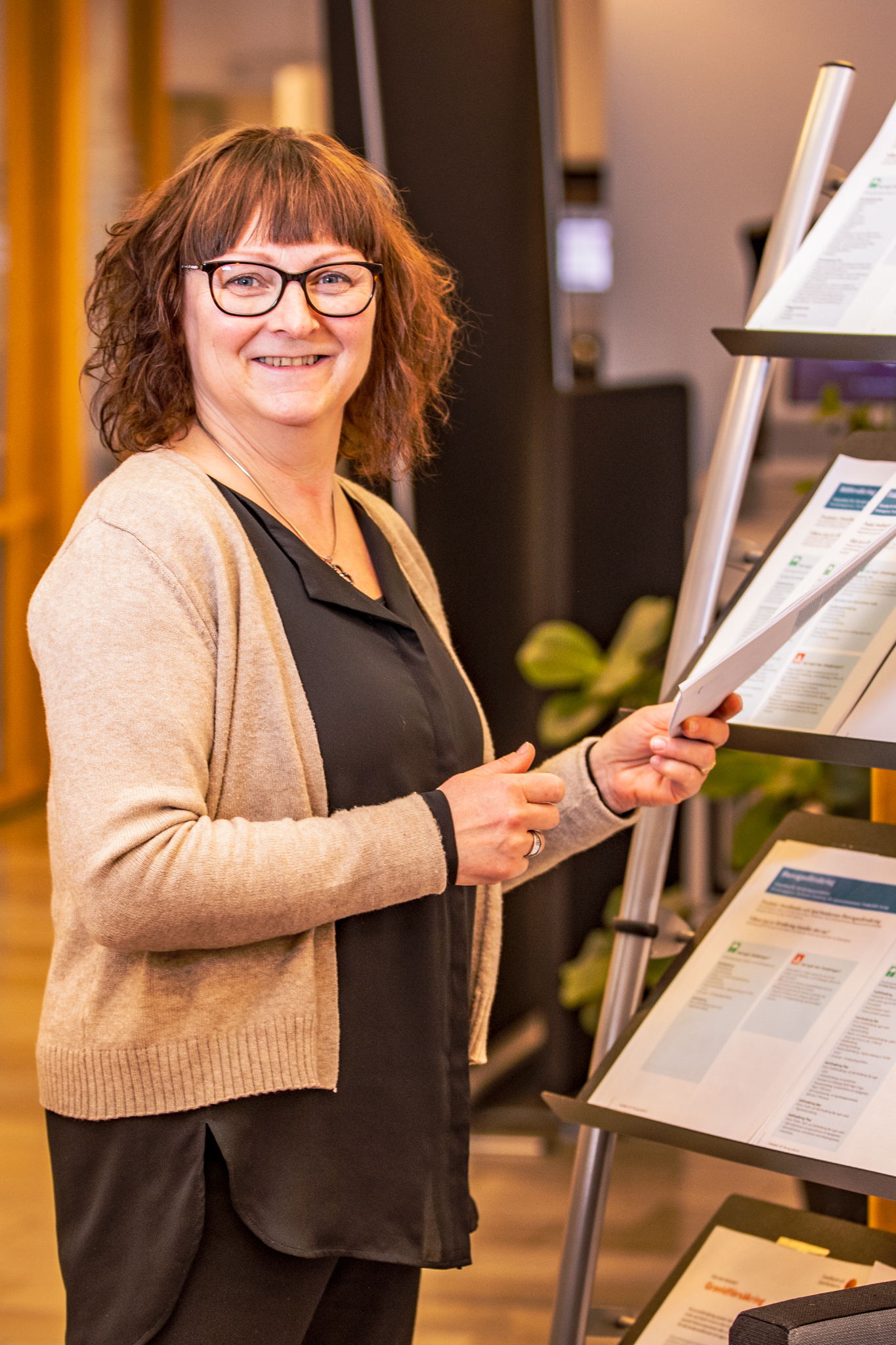 Leende kvinna som håller ett papper i handen